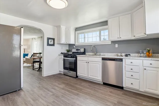 a kitchen with white cabinets and white appliances