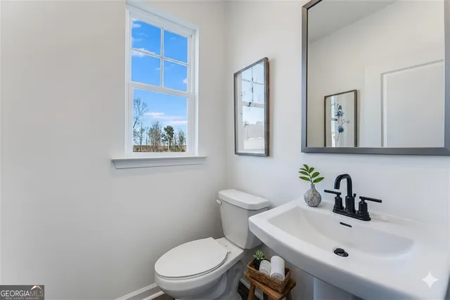 a bathroom with a toilet a sink and mirror