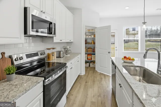 a kitchen with stainless steel appliances granite countertop a sink stove and refrigerator