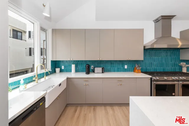 a kitchen with stainless steel appliances a stove a sink and a refrigerator