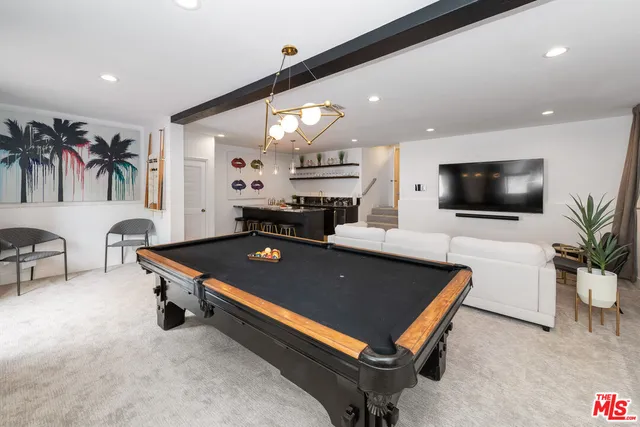 a living room with furniture pool table and a flat screen tv