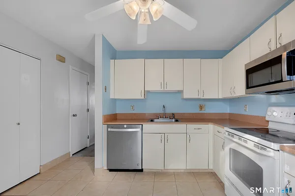 a kitchen with white cabinets stainless steel appliances and sink