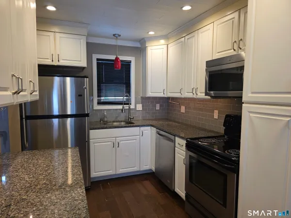 a kitchen with stainless steel appliances granite countertop a stove microwave and refrigerator