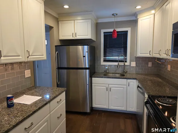 a kitchen with stainless steel appliances granite countertop a refrigerator sink and stove