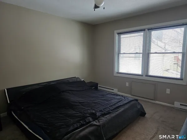 a bed sitting in a bedroom next to a window