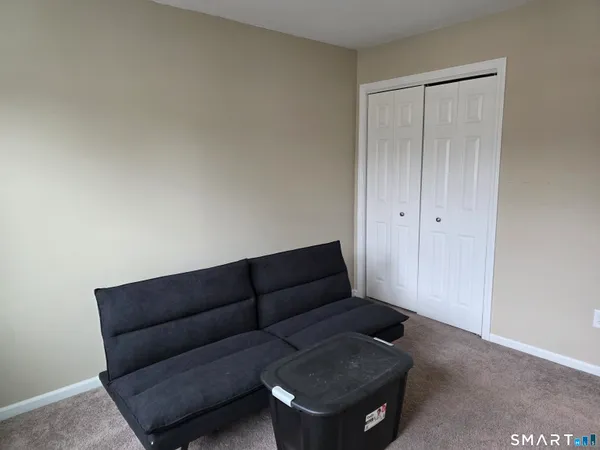 a living room with furniture and a air conditioner vent