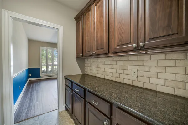 a kitchen with granite countertop a sink a stove and cabinets