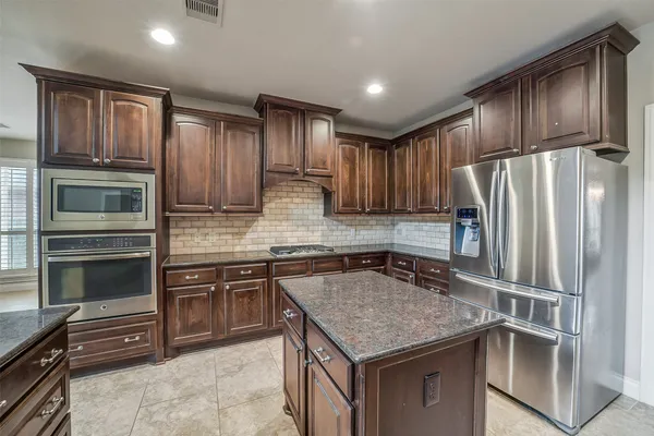 a kitchen with stainless steel appliances granite countertop a refrigerator stove and oven