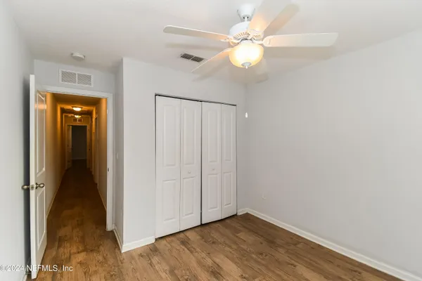 a view of an empty room with wooden floor