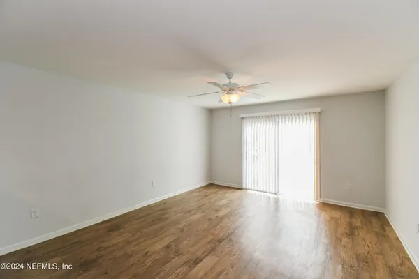 a view of an empty room with wooden floor