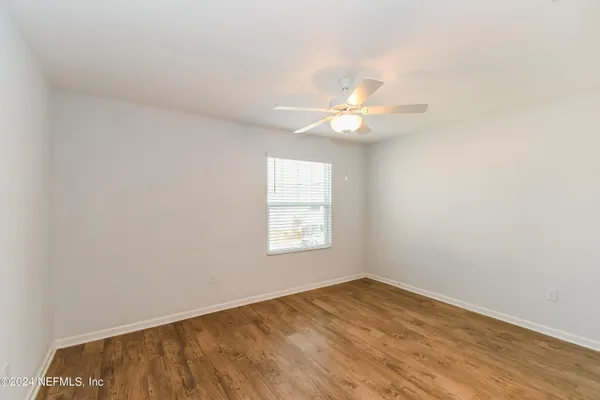 an empty room with a window and a fan