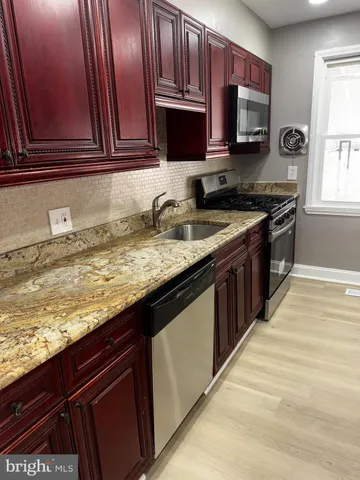 a kitchen with stainless steel appliances granite countertop a sink stove and microwave