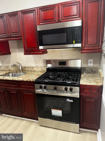 a kitchen with granite countertop wood cabinets and stainless steel appliances