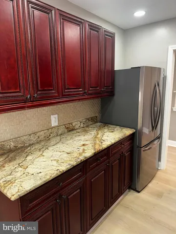 a view of kitchen with granite countertop wooden cabinets
