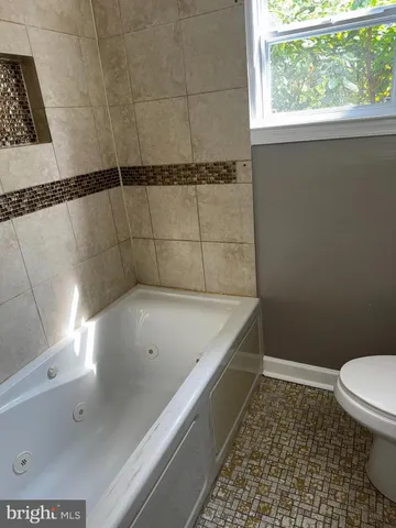 a bathroom with a bathtub and window