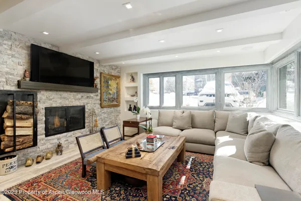 a living room with furniture a flat screen tv and a fireplace