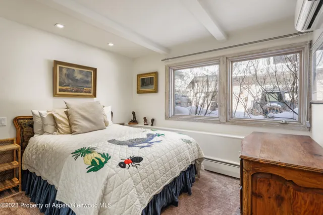 a bedroom with a bed and a large window