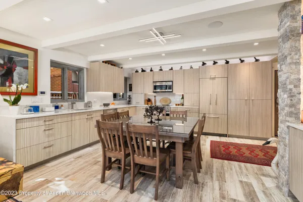 a dining hall with stainless steel appliances a table and chairs