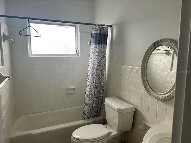 a bathroom with a toilet a sink and a mirror