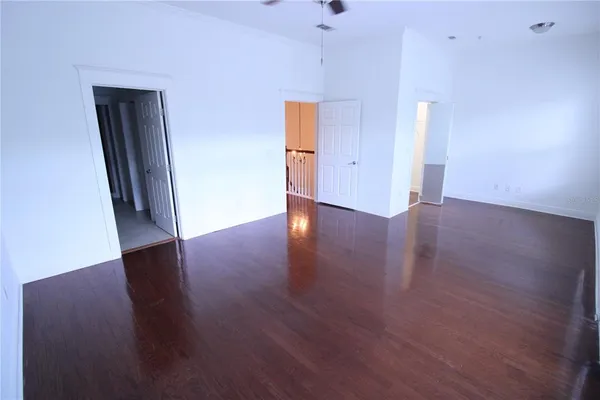 an empty room with wooden floor and mirror