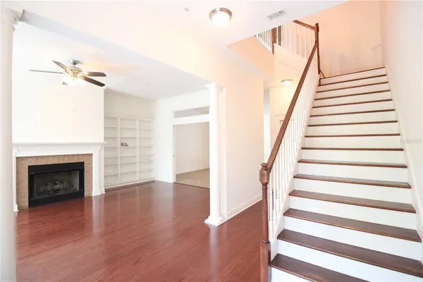 a view of a livingroom with wooden floor and a fireplace