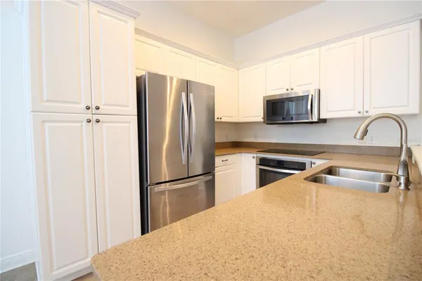 a kitchen with stainless steel appliances a refrigerator sink and cabinets