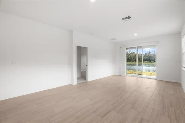 a view of empty room with kitchen and window