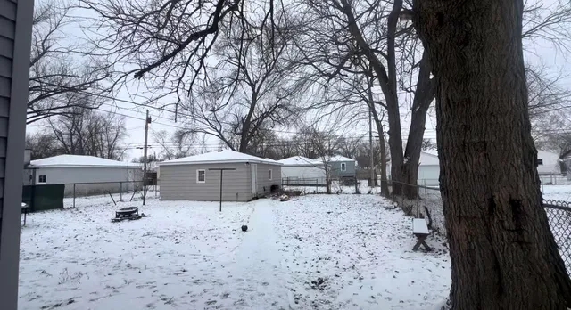 a front view of a house with a yard covered in snow