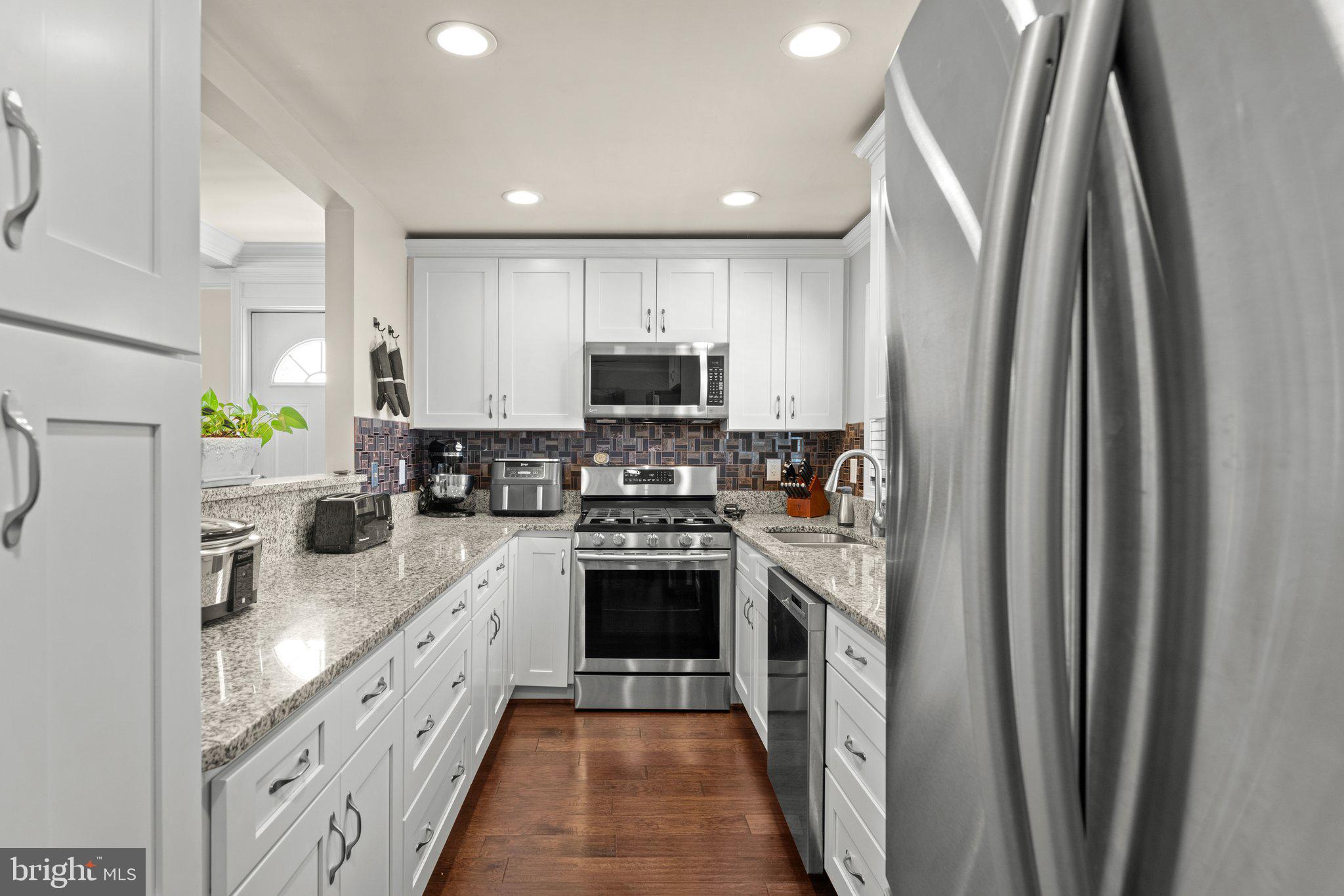 6408 Zekan Lane Springfield, VA 22150 - Photo 18 of 72 a kitchen with stainless steel appliances granite countertop a refrigerator and a stove top oven