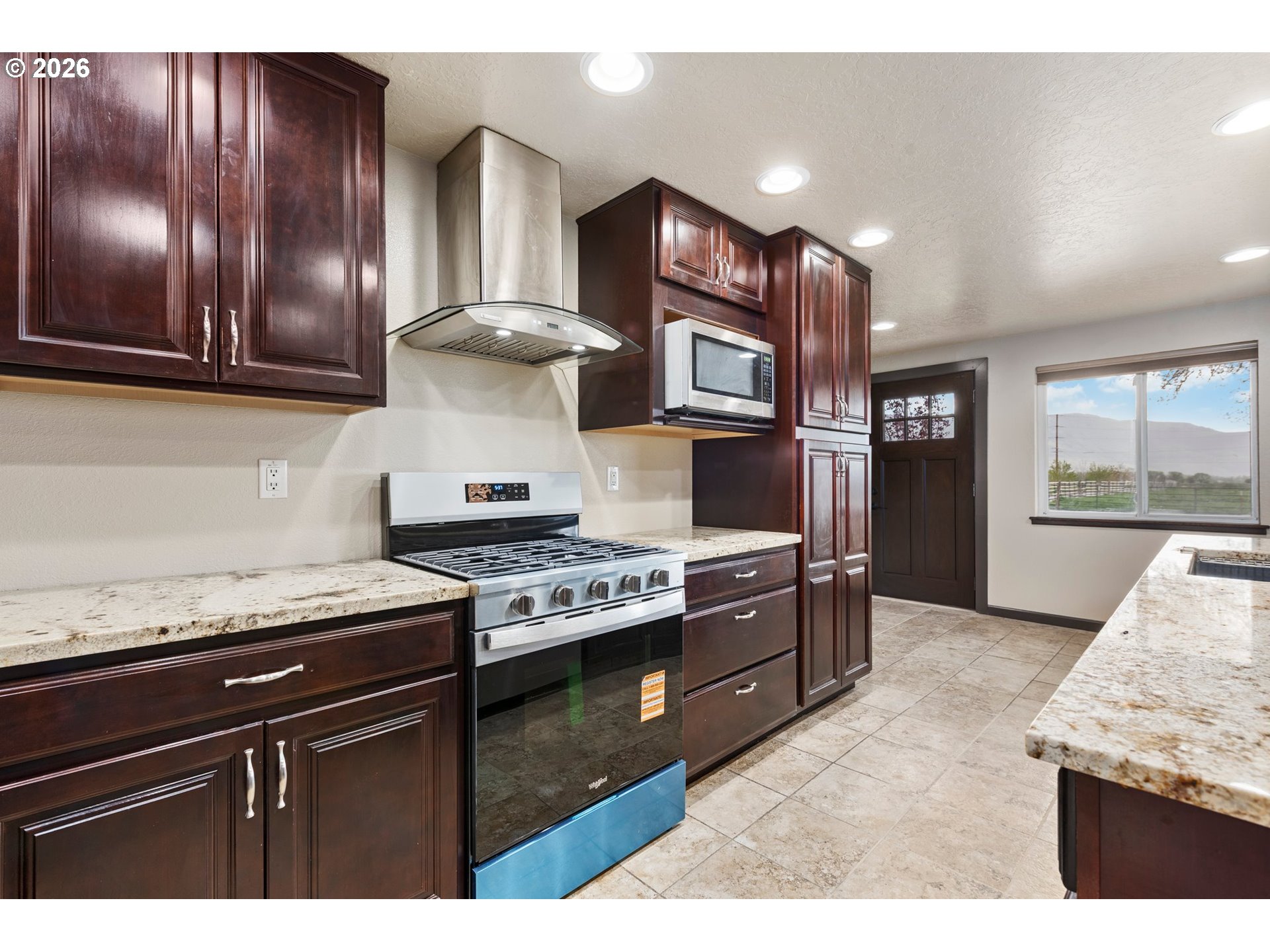 58015 Godley Road Union, OR 97883 - Photo 6 of 44 a kitchen with stainless steel appliances granite countertop wooden cabinets stove top oven and sink