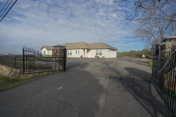 a view of an empty room and chandelier fan
