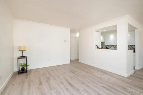 an empty room with wooden floor and a hallway