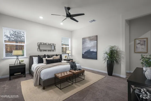 a bedroom with a bed a couch and a potted plant