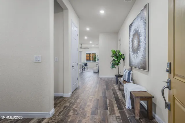 a view of a hallway with wooden floor and furniture