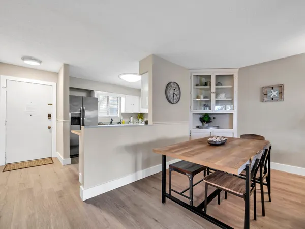 a kitchen with stainless steel appliances a refrigerator a stove a sink dishwasher and white cabinets with wooden floor