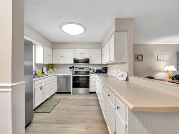 a kitchen with granite countertop white cabinets and white appliances