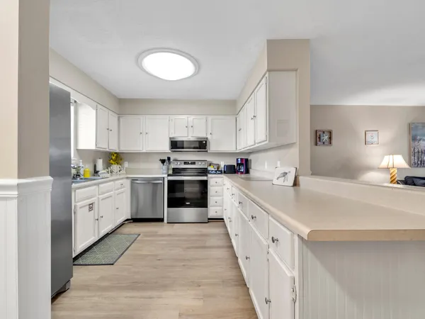 a kitchen with stainless steel appliances granite countertop a refrigerator sink and stove