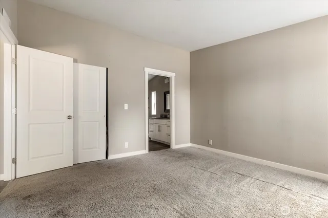 a view of an empty room with closet and a window