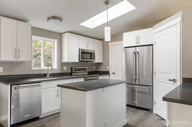 a kitchen with white cabinets and stainless steel appliances
