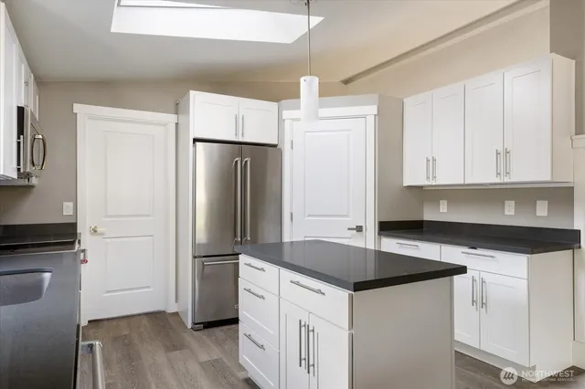 a kitchen with granite countertop a refrigerator and a sink