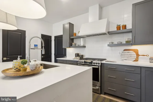 a kitchen with stainless steel appliances granite countertop a sink a stove and refrigerator