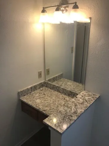 a bathroom with a granite countertop sink and shower