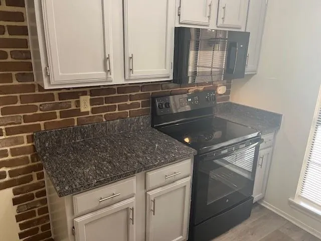 a kitchen with granite countertop a sink and cabinets
