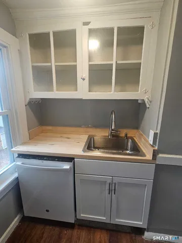 a view of a sink and dishwasher with wooden floor