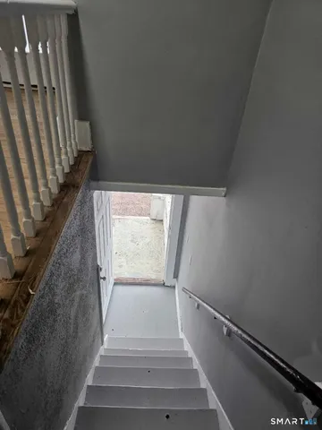 a view of staircase with white walls and a window