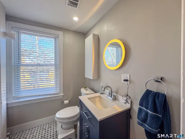 a bathroom with a toilet a sink and mirror