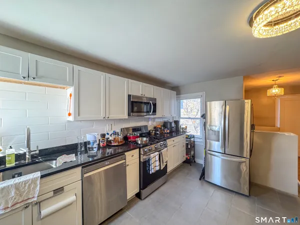 a kitchen with stainless steel appliances a refrigerator a sink a stove a microwave and cabinets