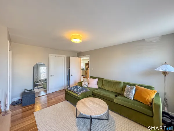 a living room with furniture a flat screen tv and a bookshelf