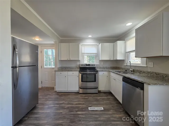 a kitchen with a refrigerator stove top oven and sink
