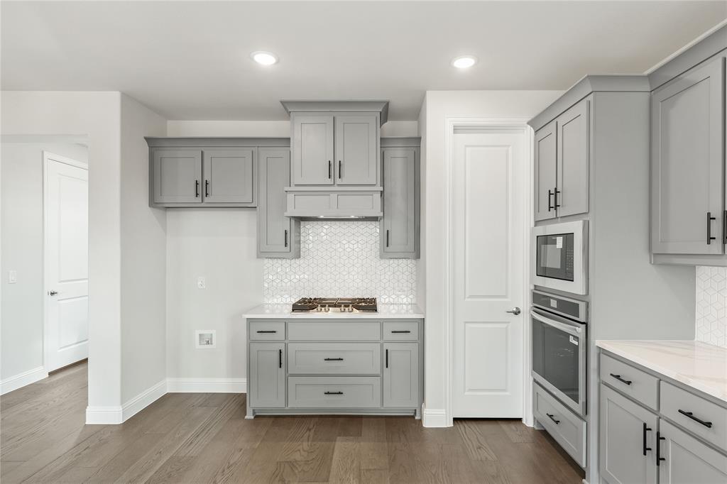 8 Grouse Circle Sanger, TX 76266 - Photo 12 of 40 a kitchen with white cabinets and stainless steel appliances